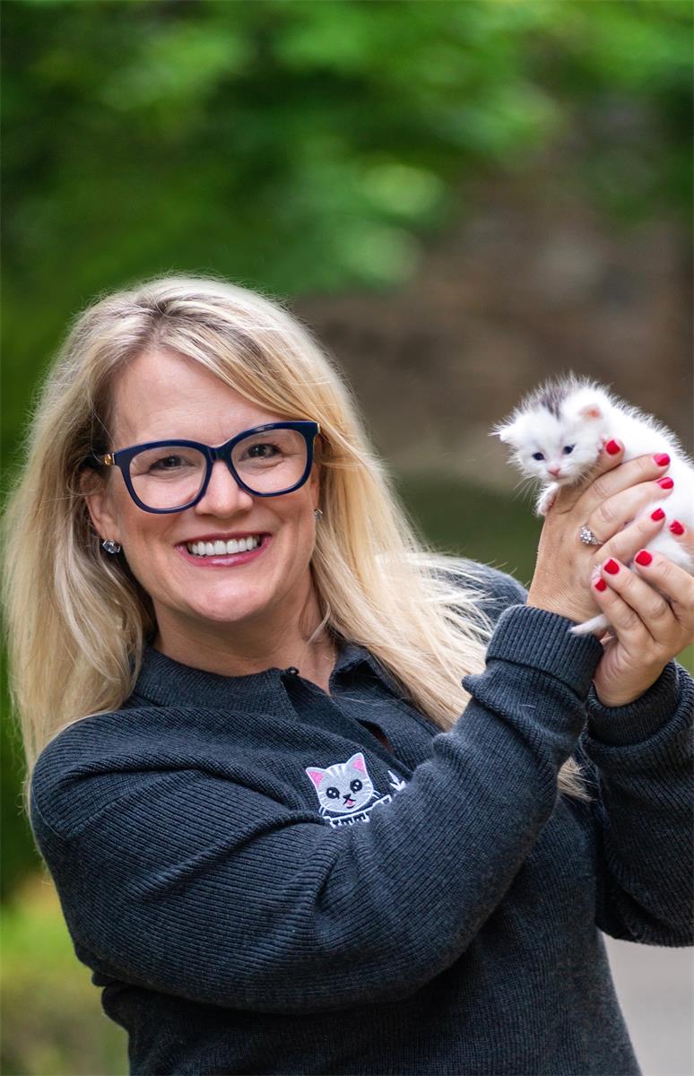 Marnie holding up an adorable white and grey kitten